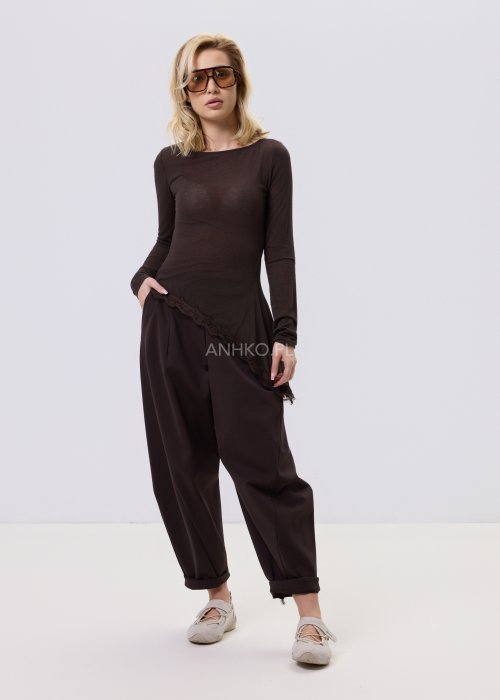 Ciemnobrązowe spodnie damskie Basco z szeroką nogawką zwężaną ku dołowi i gumką w pasie, zestawione ze sportowym obuwiem w stylizacji casualowej