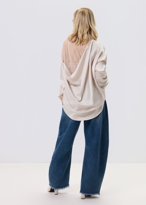 Jeansy damskie Driftline w kolorze ciemnego denimu o szerokiej nogawce i surowym wykończeniu dołu, stylizowane z jasnym topem i botkami na obcasie.