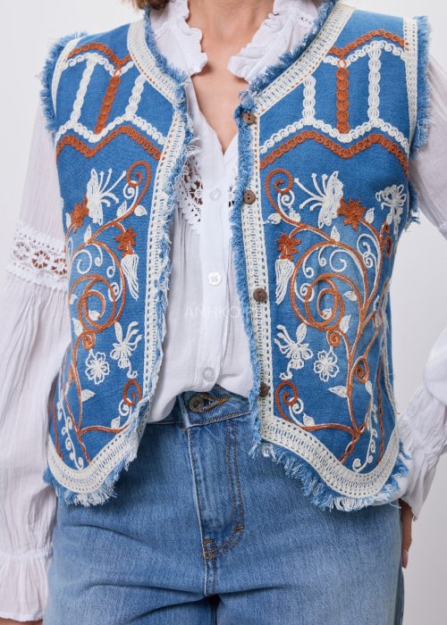 Jeansowa kamizelka Cowgirl New Orange z haftowanymi motywami boho w odcieniach pomarańczu i bieli, noszona na białą bluzkę i jeansy.