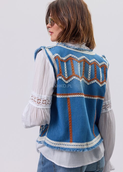 Jeansowa kamizelka Cowgirl New Orange z haftowanymi motywami boho w odcieniach pomarańczu i bieli, noszona na białą bluzkę i jeansy.