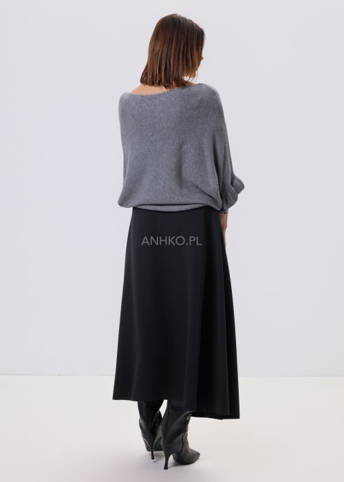 Szary sweter damski oversize z dekoracyjną falbaną na rękawie, gładka dzianina i luźny fason, stylizacja z czarnymi spodniami.