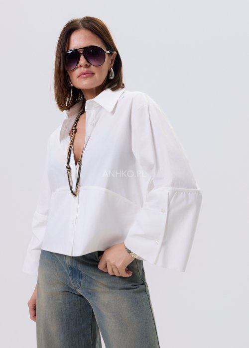 Biała koszula damska Velin Soft o luźnym kroju z długim rękawem i minimalistycznym wykończeniem, stylizowana z szerokimi spodniami i botkami.