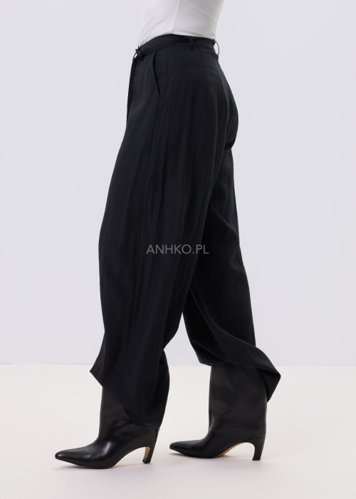 Czarne spodnie damskie z szeroką nogawką i wiązaniem w pasie, elegancki fason, stylizacja z białą bluzką i botkami.