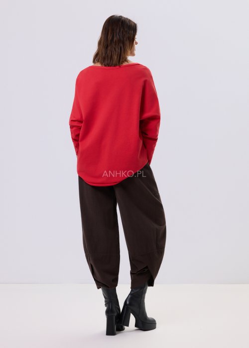 Brązowe spodnie sztruksowe o luźnym kroju z elastyczną talią i naszywanymi kieszeniami, zestawione ze sneakersami w casualowej, miejskiej stylizacji.