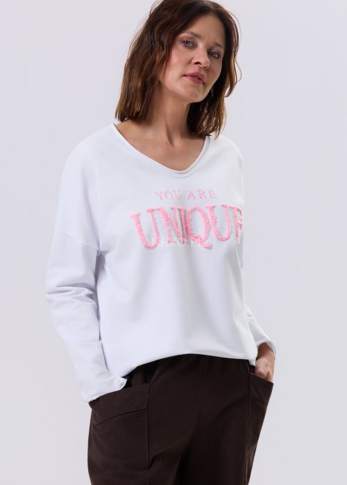 Biała bluzka damska Script z haftem YOU ARE UNIQUE, luźny krój relaxed, dekolt V i asymetryczny dół, styl casual miejski.