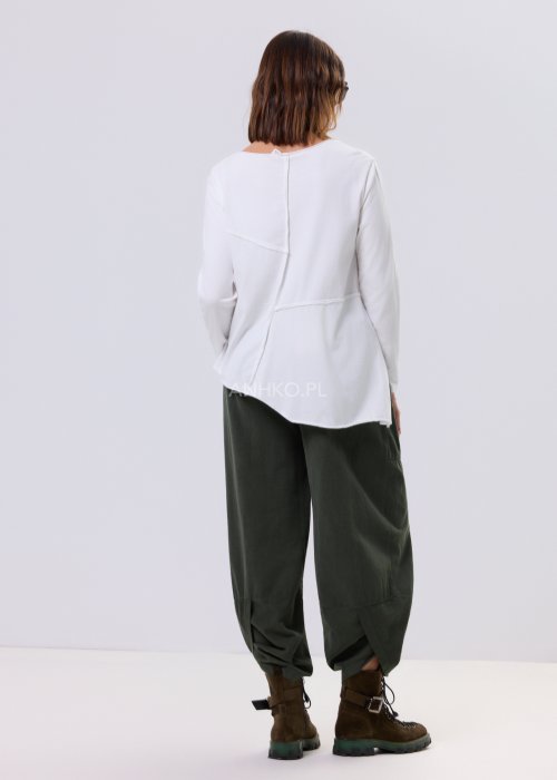 Biała bluzka damska Flux Top z asymetrycznym dołem, dekolt V-neck, długie rękawy i surowe przeszycia, styl miejski casual.