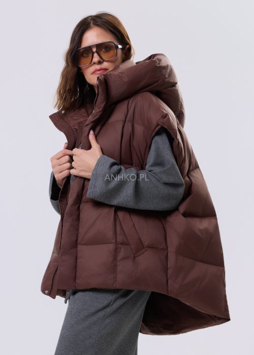 Brązowa kamizelka puchowa z kapturem i pikowaniem, zestawiona z szarym kompletem dresowym w miejskiej, casualowej stylizacji.