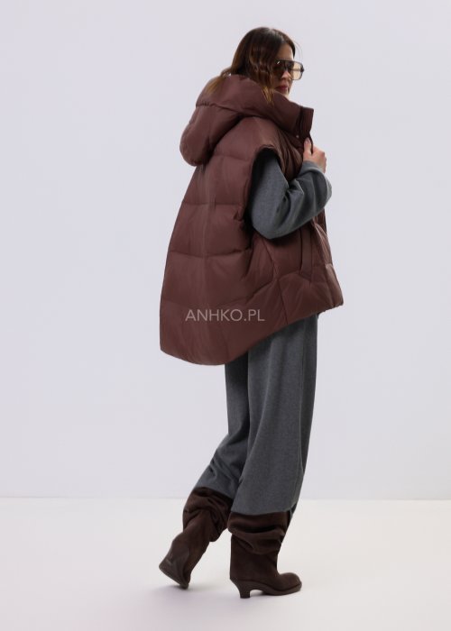 Brązowa kamizelka puchowa z kapturem i pikowaniem, zestawiona z szarym kompletem dresowym w miejskiej, casualowej stylizacji.