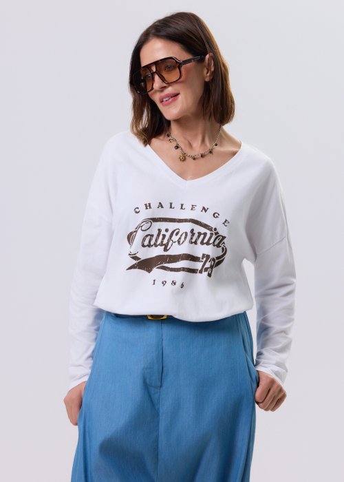 Biała bluzka damska z dekoltem V i nadrukiem California w stylu vintage, luźny krój relaxed fit, długi rękaw, styl miejski casual.