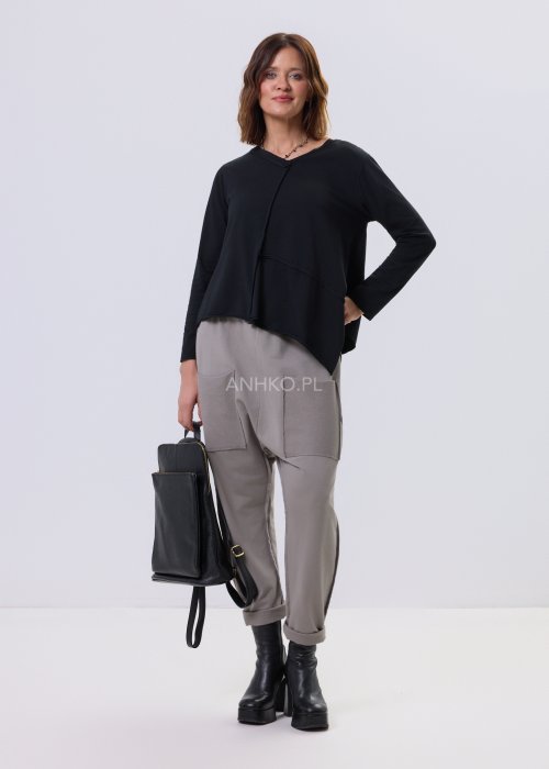 Czarna bluzka Flux Top z asymetrycznym dołem, dekolt V-neck, surowe przeszycia i luźny krój relaxed w stylu miejskim.