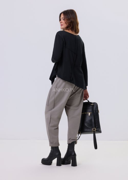 Czarna bluzka Flux Top z asymetrycznym dołem, dekolt V-neck, surowe przeszycia i luźny krój relaxed w stylu miejskim.