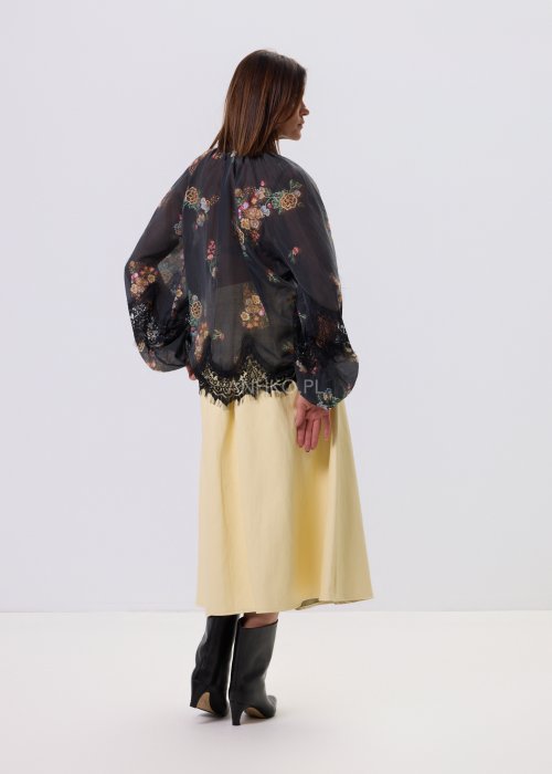 Czarna bluzka Liora Bloom w kwiaty z koronkowym wykończeniem, luźny fason, wiązanie przy szyi i długie rękawy, styl boho elegancki.