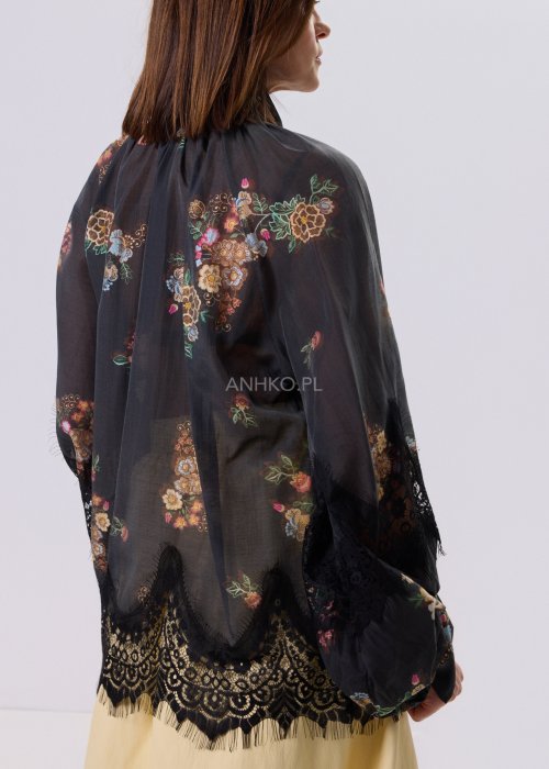 Czarna bluzka Liora Bloom w kwiaty z koronkowym wykończeniem, luźny fason, wiązanie przy szyi i długie rękawy, styl boho elegancki.