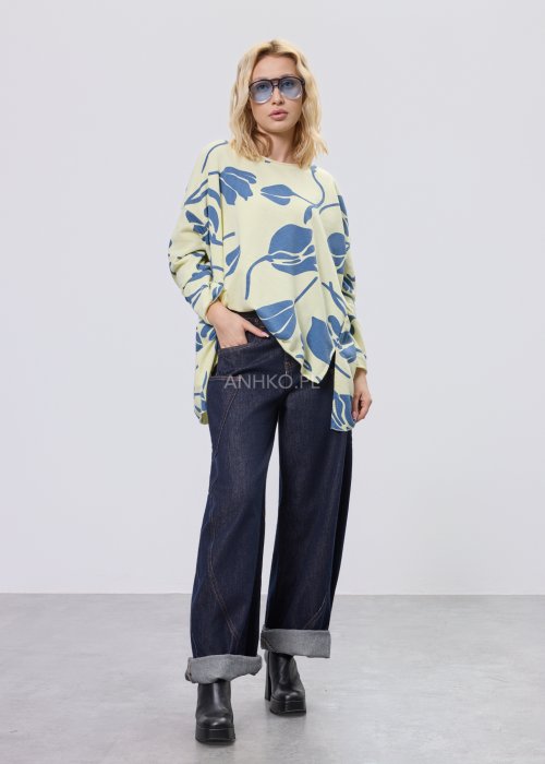 Żółta bluza damska oversize z niebieskim, graficznym wzorem roślinnym, luźny fason w stylizacji z ciemnymi jeansami.