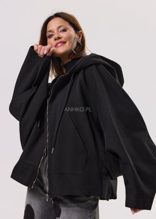 Czarna kurtka damska oversize z kapturem i zamkiem, zestawiona z jeansami z motywem serc w stylu streetwear.