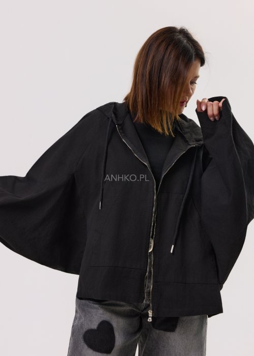 Czarna kurtka damska oversize z kapturem i zamkiem, zestawiona z jeansami z motywem serc w stylu streetwear.