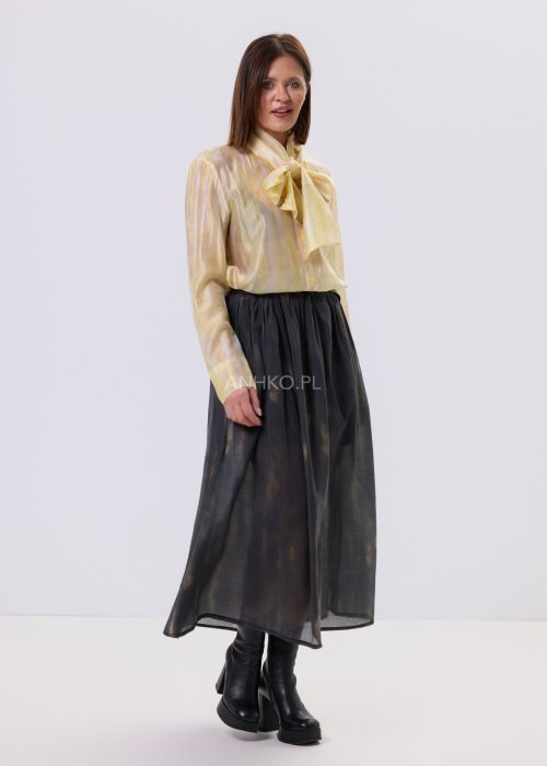 Masełkowa elegancka bluzka z wiązaną kokardą przy szyi i długim rękawem. Stylizacja z czarną spódnicą i paskiem podkreślającym talię.