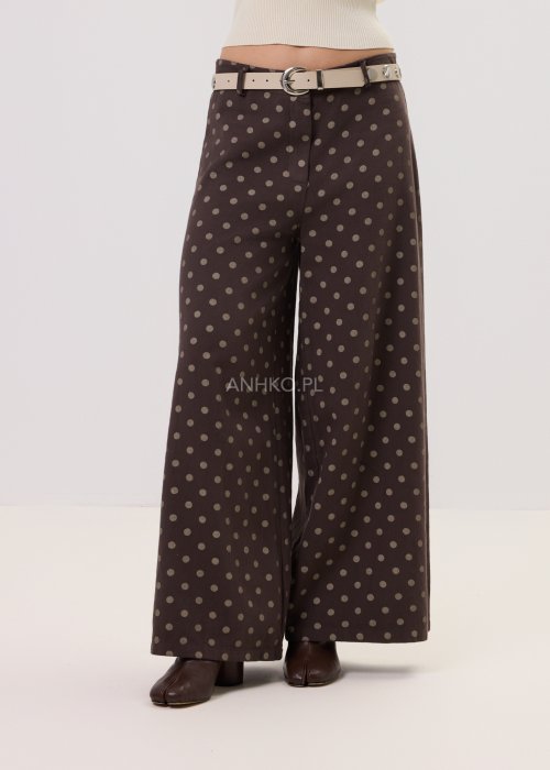 22013298.jpgBrązowe damskie spodnie Retro Dots z szeroką nogawką, ozdobione beżowymi groszkami. Model z wysokim stanem i paskiem w talii, w stylizacji z kremowym topem oraz brązowymi botkami.