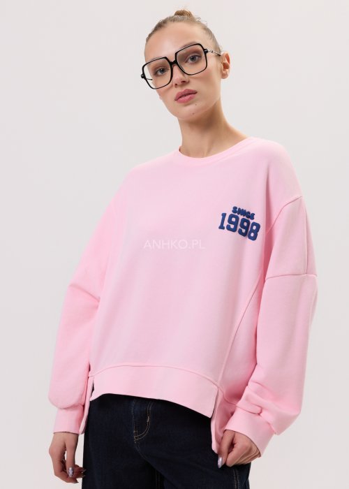 Różowa bluza oversize damska Since 1998 z granatowym nadrukiem, luźny fason, zestawiona z szerokimi jeansami.