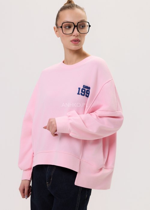 Różowa bluza oversize damska Since 1998 z granatowym nadrukiem, luźny fason, zestawiona z szerokimi jeansami.