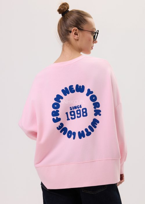 Różowa bluza oversize damska Since 1998 z granatowym nadrukiem, luźny fason, zestawiona z szerokimi jeansami.