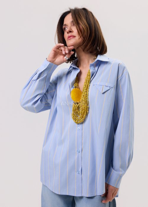 Błękitna damska koszula Lemon Flow w delikatne żółte paski, o luźnym, lekko oversize’owym kroju. Model zapinany na guziki, z klasycznym kołnierzykiem i kieszenią na piersi.