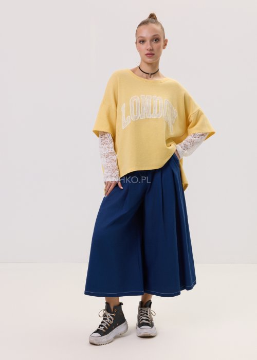 Żółta bluza damska Londyn Noa o luźnym, oversize’owym kroju z krótkim rękawem. Model z dużym napisem „London” na przodzie oraz rozcięciami po bokach.