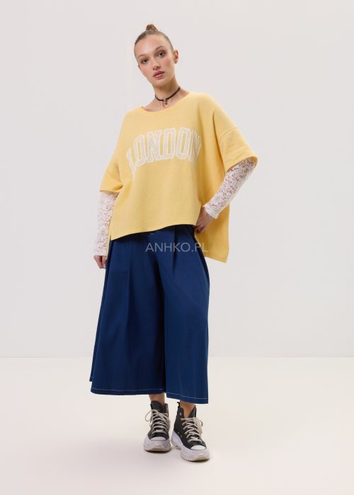 Żółta bluza damska Londyn Noa o luźnym, oversize’owym kroju z krótkim rękawem. Model z dużym napisem „London” na przodzie oraz rozcięciami po bokach.