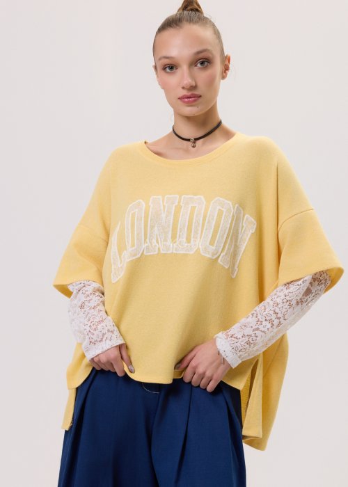 Żółta bluza damska Londyn Noa o luźnym, oversize’owym kroju z krótkim rękawem. Model z dużym napisem „London” na przodzie oraz rozcięciami po bokach.