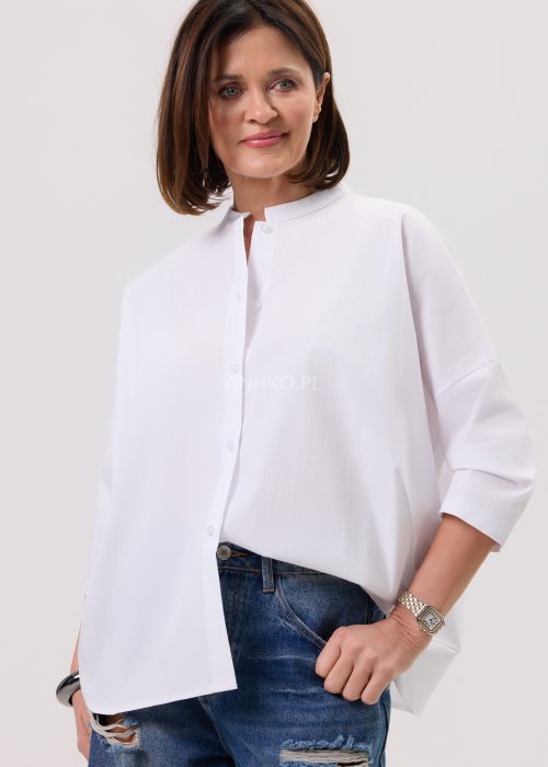 Damska biała koszula o luźnym kroju z obniżoną linią ramion, tył lekko wydłużony, zestawiona z denimem.