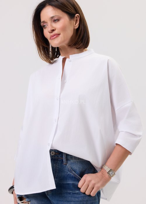 Damska biała koszula o luźnym kroju z obniżoną linią ramion, tył lekko wydłużony, zestawiona z denimem.