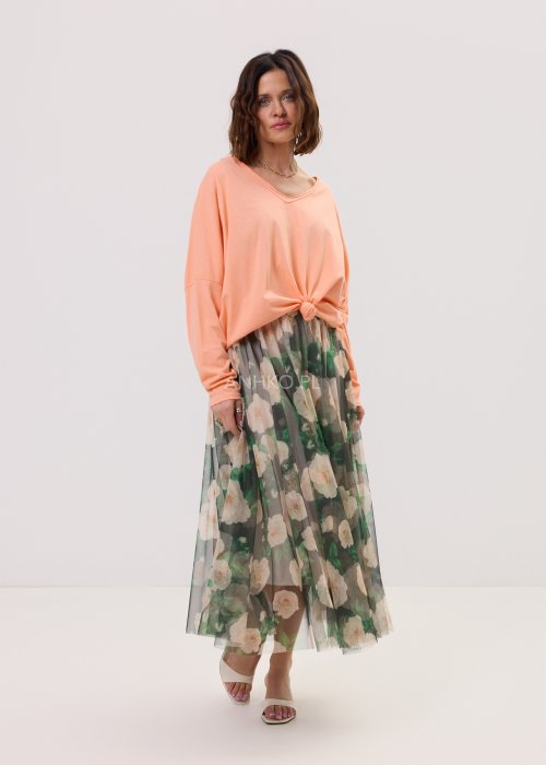 Brzoskwiniowa bluzka damska Anio o luźnym, oversize’owym fasonie z dekoltem V i długim rękawem, zestawiona ze zwiewną spódnicą w kwiaty w kobiecej stylizacji.