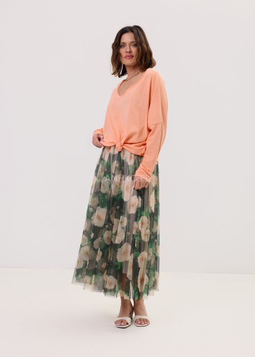 Brzoskwiniowa bluzka damska Anio o luźnym, oversize’owym fasonie z dekoltem V i długim rękawem, zestawiona ze zwiewną spódnicą w kwiaty w kobiecej stylizacji.