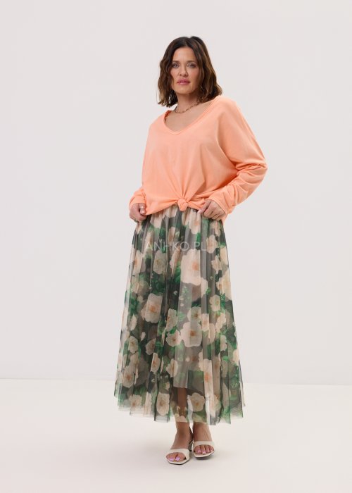 Brzoskwiniowa bluzka damska Anio o luźnym, oversize’owym fasonie z dekoltem V i długim rękawem, zestawiona ze zwiewną spódnicą w kwiaty w kobiecej stylizacji.