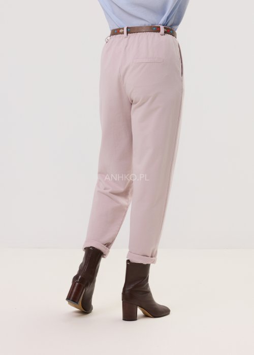 Pudrowe spodnie damskie chino o zwężanym kroju z podwijaną nogawką i paskiem, styl elegancki casual.