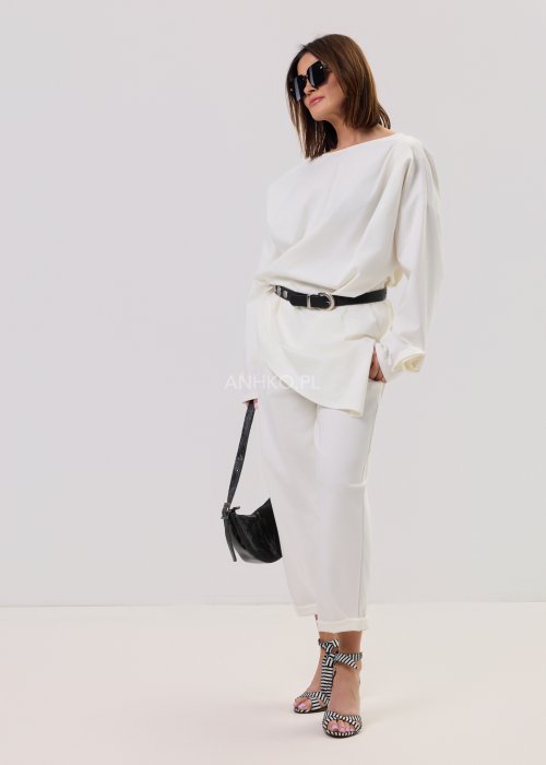 Białe spodnie Starola Rose z podwiniętą nogawką i eleganckim paskiem, luźny fason z zakładkami z przodu, w stylizacji z sandałami na słupku w czarno-białe paski.