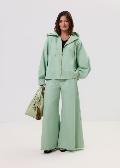 Kurtka damska oversize z kapturem, o krótszym kroju z tyłu z ozdobnym nadrukiem i metalowym kółkiem na plecach.