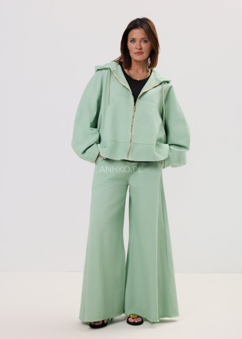 Kurtka damska oversize z kapturem, o krótszym kroju z tyłu z ozdobnym nadrukiem i metalowym kółkiem na plecach.