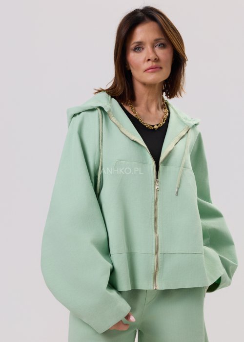 Kurtka damska oversize z kapturem, o krótszym kroju z tyłu z ozdobnym nadrukiem i metalowym kółkiem na plecach.