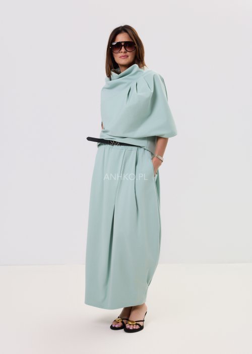 Miętowa damska bluzka o luźnym kroju z krótkim rękawem, szerokim dekoltem typu woda i dekoracyjnymi zakładkami z przodu.