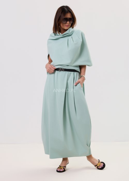 Miętowa damska bluzka o luźnym kroju z krótkim rękawem, szerokim dekoltem typu woda i dekoracyjnymi zakładkami z przodu.