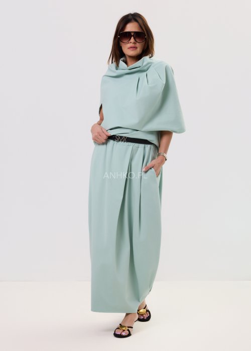 Miętowa damska bluzka o luźnym kroju z krótkim rękawem, szerokim dekoltem typu woda i dekoracyjnymi zakładkami z przodu.