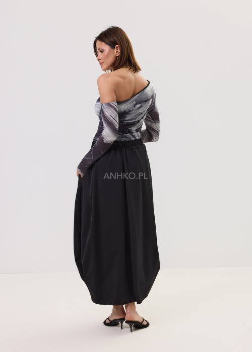 Bluzka dopasowana na jedno ramię z długim rękawem w marmurkowy wzór w odcieniach czerni, szarości i bieli. Nowoczesna stylizacja z czarną spódnicą w eleganckim, minimalistycznym stylu.