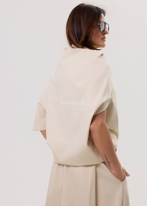 Beżowa damska bluzka o luźnym kroju z krótkim rękawem, szerokim dekoltem typu woda i dekoracyjnymi zakładkami z przodu.