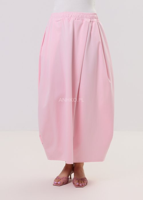 Różowa spódnica maxi o luźnym, nowoczesnym kroju z elastyczną gumką w pasie i miękko układającą się tkaniną, prezentowana na modelce w minimalistycznej stylizacji.