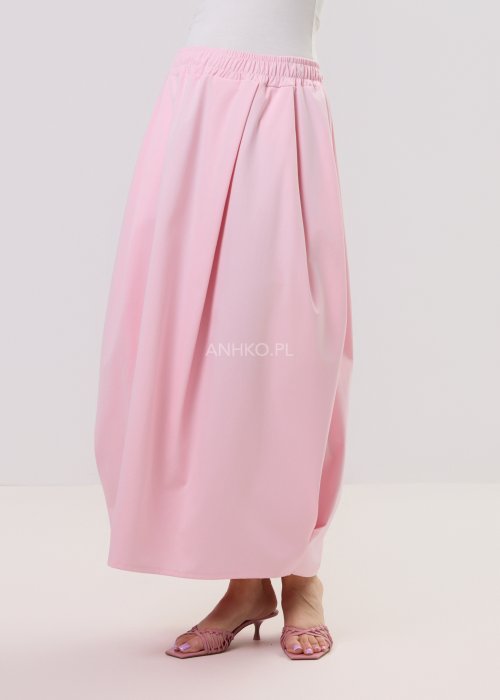 Różowa spódnica maxi o luźnym, nowoczesnym kroju z elastyczną gumką w pasie i miękko układającą się tkaniną, prezentowana na modelce w minimalistycznej stylizacji.