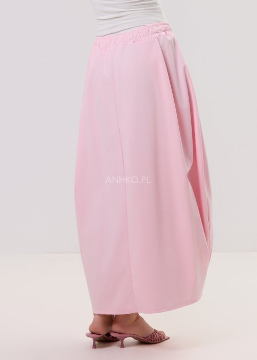 Różowa spódnica maxi o luźnym, nowoczesnym kroju z elastyczną gumką w pasie i miękko układającą się tkaniną, prezentowana na modelce w minimalistycznej stylizacji.