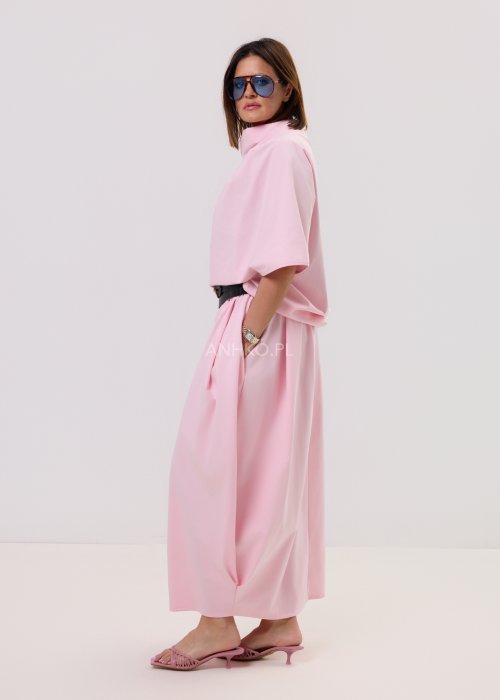 Różowa spódnica maxi o luźnym, nowoczesnym kroju z elastyczną gumką w pasie i miękko układającą się tkaniną, prezentowana na modelce w minimalistycznej stylizacji.