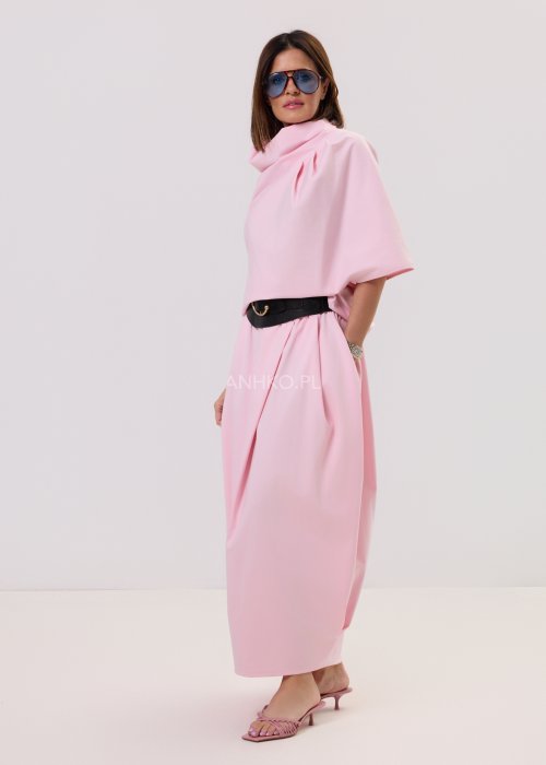 Różowa bluzka damska o nowoczesnym, minimalistycznym kroju z szerokim, drapowanym kołnierzem i luźnym fasonem, prezentowana na modelce w eleganckiej stylizacji.