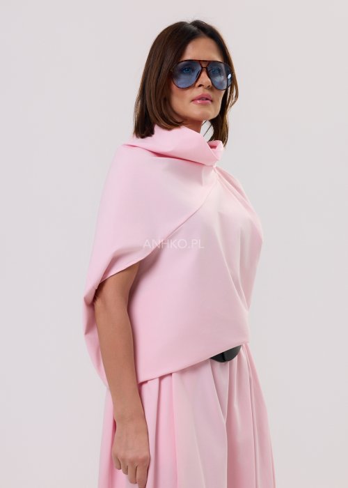 Różowa bluzka damska o nowoczesnym, minimalistycznym kroju z szerokim, drapowanym kołnierzem i luźnym fasonem, prezentowana na modelce w eleganckiej stylizacji.